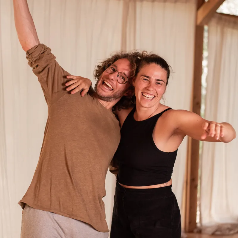 Jonathan en Nicole lachen met de armen om elkaar heen in de opnameruimte
