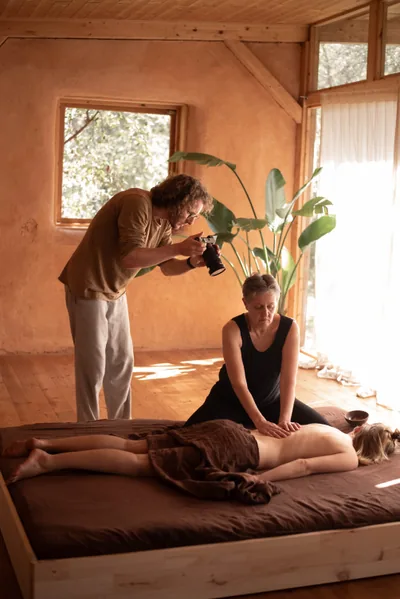 Jonathan met de camera in de hand tijdens een opname van een rugmassage in de lemen opnameruimte